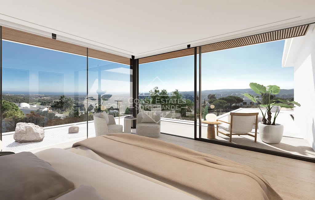 Luxury bedroom in a Sotogrande villa with floor-to-ceiling glass windows and stunning panoramic views.