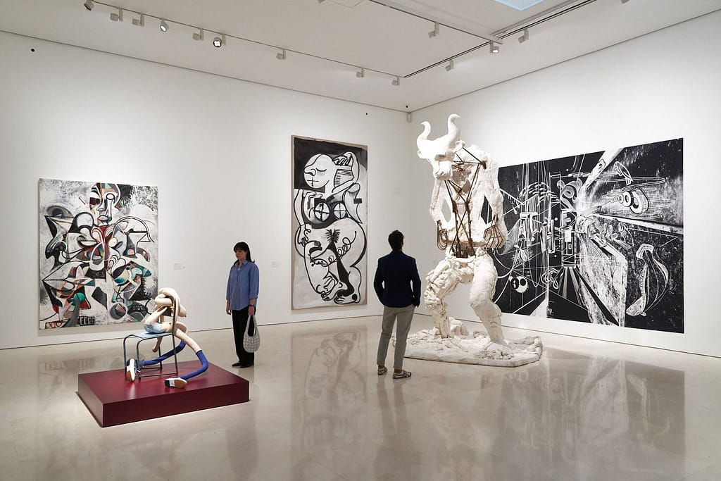 Visitors admiring modern art sculptures and paintings in a contemporary gallery in Sotogrande, Spain