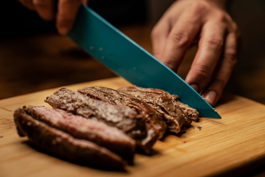 Chef slicing a juicy steak at a top restaurant in Sotogrande