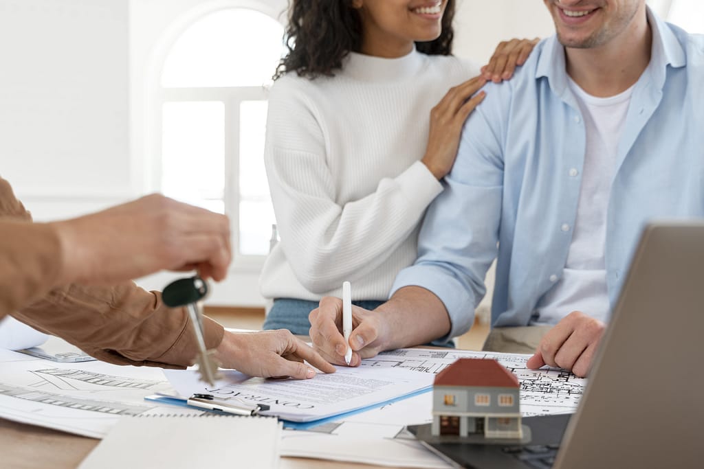 Happy couple signing contract to buy Sotogrande property with keys being handed over