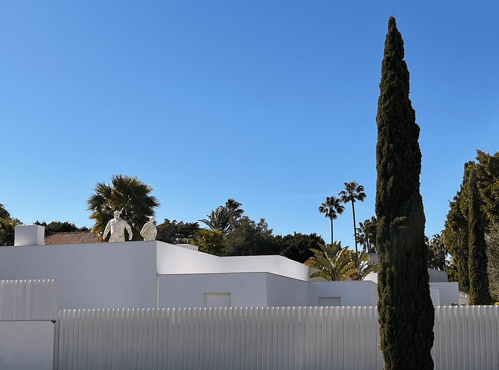 A group of houses in a private setting, surrounded by trees in their gardens, on a sunny day. This scene exemplifies the allure of Sotogrande real estate, offering tranquil and exclusive residential living.