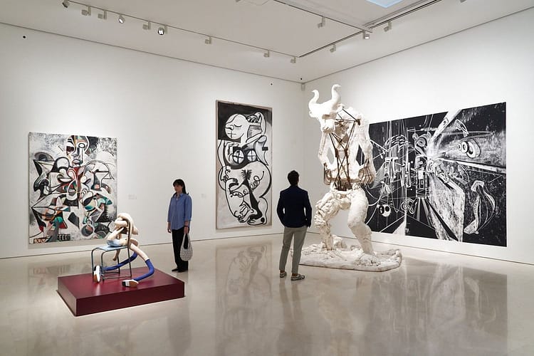 Visitors admiring modern art sculptures and paintings in a contemporary gallery in Sotogrande, Spain