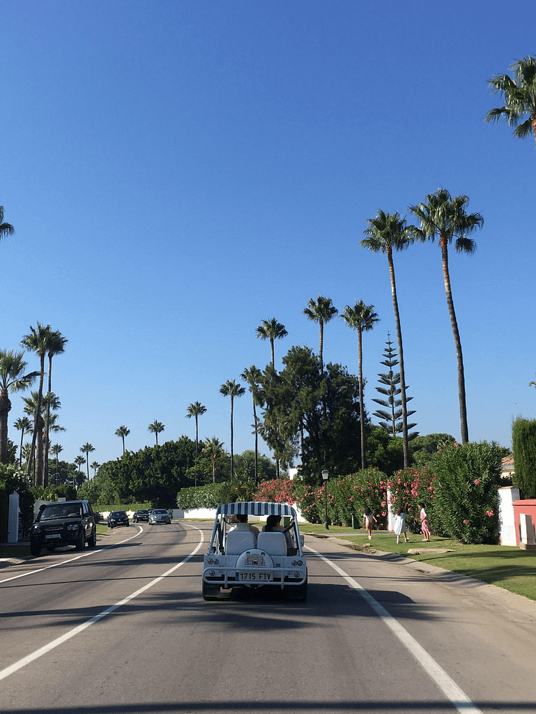 A vehicle drives down the boulevard in what appears to be a private and tranquil area, showcasing the exclusive residential neighborhoods of Sotogrande real estate.